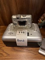 Kodak EasyShare digital camera placed on top of a Kodak docking station with MaxSold lot label attached.