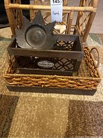 Wicker magazine rack with metal leaf decorative piece and a tray inside it