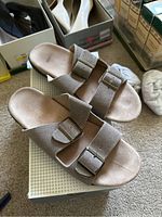 Pair of tan slide sandals with two adjustable buckles each, worn condition.