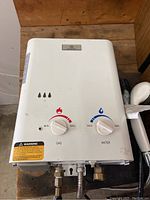 Front top view showing the unit with gas and water control knobs and warning label.