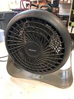 Front view of a circular black Holmes table fan with grille and base visible, showing condition and design.