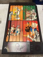 Full view of the Looney Tunes decorative folding screen with Mel Blanc image and autograph. The screen consists of 12 vertical panels with colorful cartoon character illustrations and some damage visible.