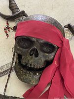 Close-up view of the pirate skull wearing a red bandana and swords behind it.