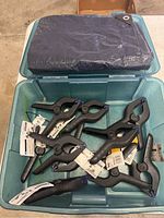 Blue folded tarp with metal reinforced corner grommets inside a plastic bin