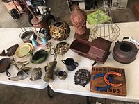 Wide view of vintage assortment on table showing ceramic, wooden, and metal decor pieces