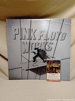 Vinyl album cover showing 'Pink Floyd Works' with industrial-themed grey design and climbing figure