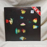 Front cover of UK vinyl record album showing color portraits of band members with red 'U.K.' band label in the top right corner.