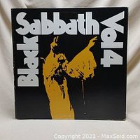 Front cover of Black Sabbath Vol 4 album with prominent yellow silhouette of band member and white text on black background.