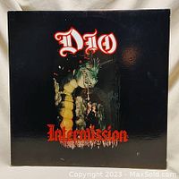 Front cover of the Dio 'Intermission' vinyl album showing album title, band logo, and artwork of a dragon and figure.