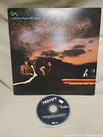 Genesis vinyl album cover and Phil Collins Testify CD single shown together.