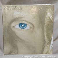 Front cover of Johnny Winter's Before the Storm double LP showing a close-up photo of his face with blue eye under shrink-wrap.