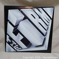 Front cover of The Firm album in 3D white block letters on black background.