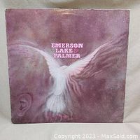 Front cover of Emerson, Lake & Palmer self-titled debut album with dove and face artwork on a purple background.