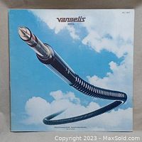 Front cover of the vinyl album 'Spiral' by Vangelis showing a large audio jack connector coiled against a cloudy sky.