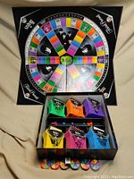 Top down view of Beatles Trivial Pursuit game board with pie tokens and cardholders arranged around it.