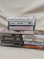 Photo of cassette tapes stack showing titles and artists like Sade, Dionne Warwick, Aretha Franklin, Shirley Horn, Jane Wiedlin, Carla Olson, Little Esther.