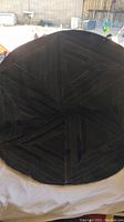 Photo showing the full round cowhide wall hanging laid flat.