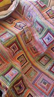Quilt laid out showing overall patchwork square design with various pastel colors.