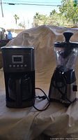 Photo showing Cuisinart coffee maker and Back to Basics juicer side by side, power cords visible.