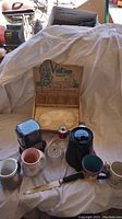 Overview of all items including coffee grinder, Keurig, cups, knife, vintage snack set box, cream and sugar set