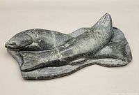 Top-down view of the soapstone carving showing two fish and the surface they rest on.