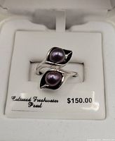 Sterling silver ring with two black pearls in calla lily design displayed in white box with price tag showing $150 Cultured Freshwater Pearl