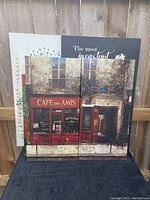 Three canvas artworks showing the cafe scene diptych, inspirational quote canvas, and floral canvas behind.