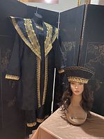 Full view of two-piece black and gold African dress on mannequin and matching headpiece on separate mannequin head