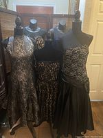 Photo of all five evening dresses displayed on mannequins showing different styles and lengths