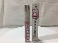 Front view of the Buxom Full-On Lip Cream lip gloss tube alongside the box showing branding and product name.