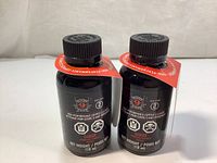 Front view of two black bottles of Hoppe's 9 Black Step 2 High Performance Copper Cleaner with red hang tags and black caps.