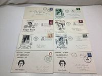 Photo showing nine First Day Cover envelopes with Queen Elizabeth II postage stamps and commemorative Royal Visit cancellations from the 1960s-70s.