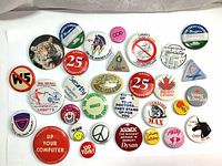 Top view of the whole lot showing diverse collection of vintage pins and button badges with varied themes and shapes.