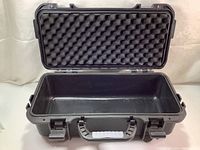 Open view of the hard black plastic case showing foam padding in the lid and empty interior.