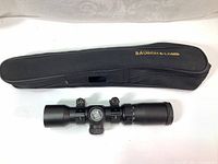 Image of black padded zippered scope case with Bausch & Lomb logo, alongside the black Excalibur scope with rings mounted