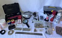 Full overview of lot showing all items including rotary tool, metal bricks, torch, spools, clamps and fasteners.