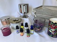 Full lot showing 6 candles, 6 essential oil bottles, decorative candle holder, and wooden crate lined in linen fabric