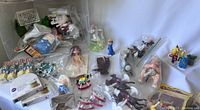 Wide shot of the assortment of vintage cake toppers, including many varied characters and boxed items, showing overall lot condition and quantity.