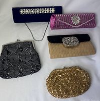 Photo showing all five vintage clutches and handbags, showing their size, shape, and embellishments.