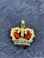 Front view of the jeweled crown pin showing detailed colored stones and gold-tone metal.