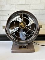 Front view of vintage Kenmore desk fan showing metal blades, cage, and control knob on base.