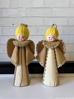 Photo of two mid century angel figurines standing side by side, showing full bodies and fabric details