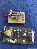 Top view showing two vibroplex telegraph keys with visible detail of red knobs, metal levers, and bases.