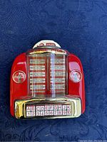 Front view of the Coca-Cola branded red jukebox style radio showing the song selection panel with letters and numbers, Coca-Cola logos, and '3 Plays' label on top.