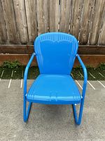 Front view of vintage blue Riviera metal lawn chair showing contoured seat and backrest.