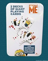 Top view of metal tin container showing "2 Decks of Giant Playing Cards" with scattered cards featuring Minion and character faces.