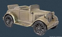 Front side view of vintage 1929 Model A cast metal brass plated coin bank showing car details and wear on wheels.