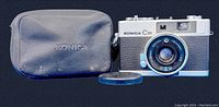 Konica C35 camera with 38mm Hexanon lens and Konica-branded protective black case