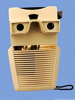 Front top view showing dual lenses and 'TALKING VIEW-MASTER' label on gold strip above speaker grill.