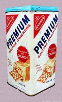 Photo of vintage 1969 Nabisco Premium Saltine Crackers 14oz metal tin container showing front and side panels with branding and cracker image, used condition.